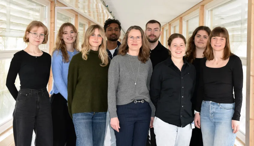 Group of smiling researchers in a corridor. Photo.